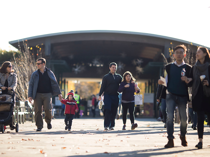 Adults and kids are walking at New York Botanical Garden