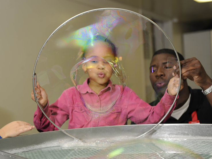 Girl is blowing a soap bubble